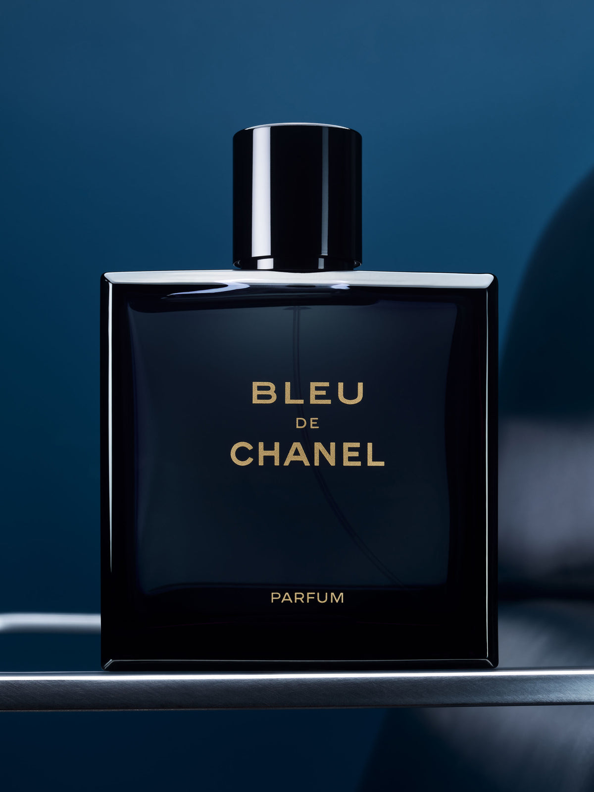 Chanel Bleu de Chanel 100ML parfum bottle with sleek rectangular design and blue label, displayed on a neutral background.