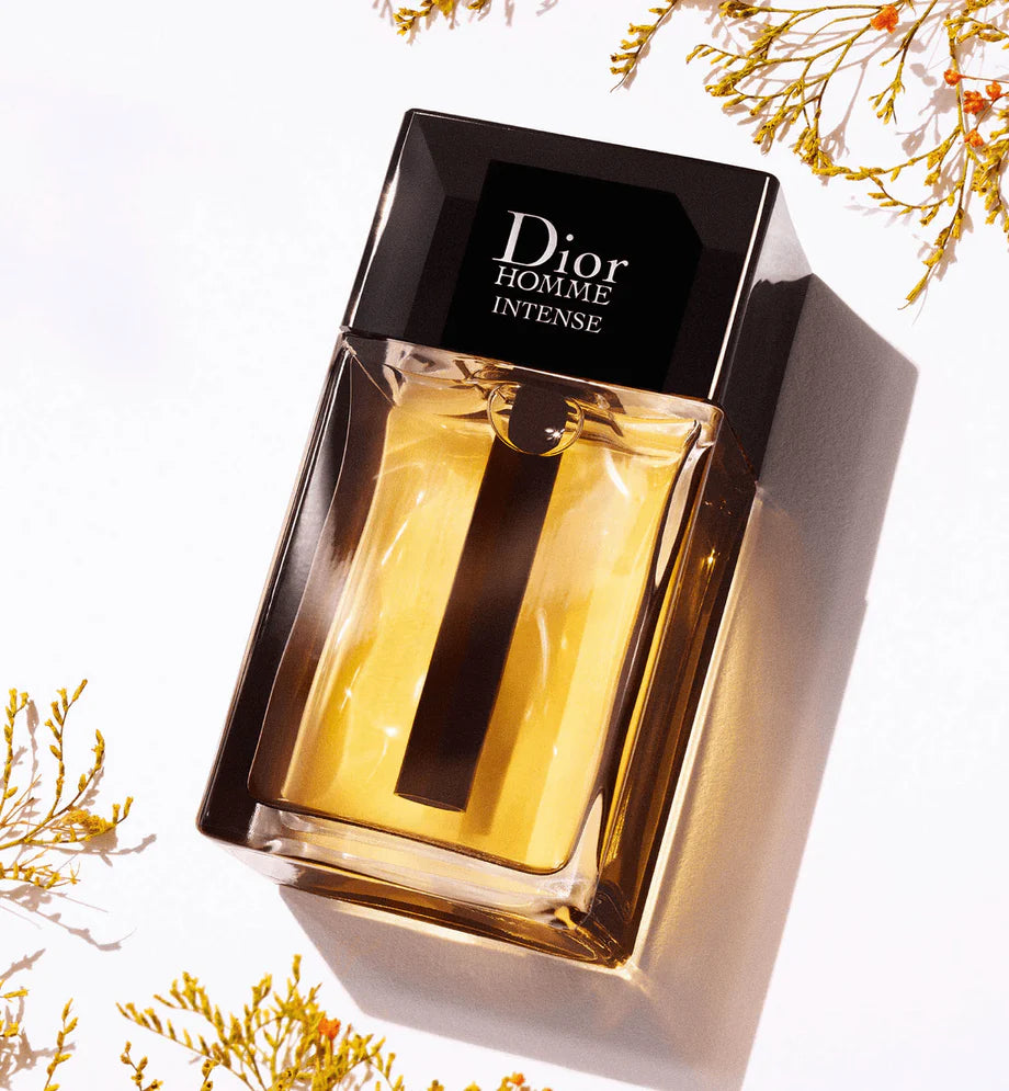 Dior Homme Intense 100ml perfume bottle with sleek glass design and metallic accents, standing upright on a reflective surface.
