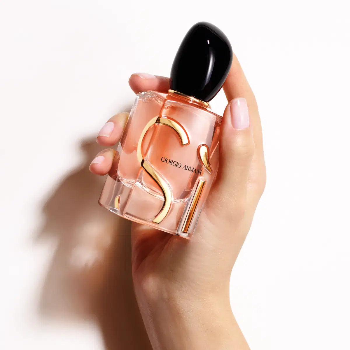 Giorgio Armani SI Eau de Parfum Intense bottle held in hand, showcasing elegant design and dark glass packaging.